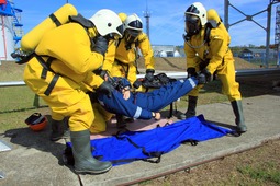 Спасатели НАСФ перекладывают пострадавшего на носилки для его передачи на санитарный пост.